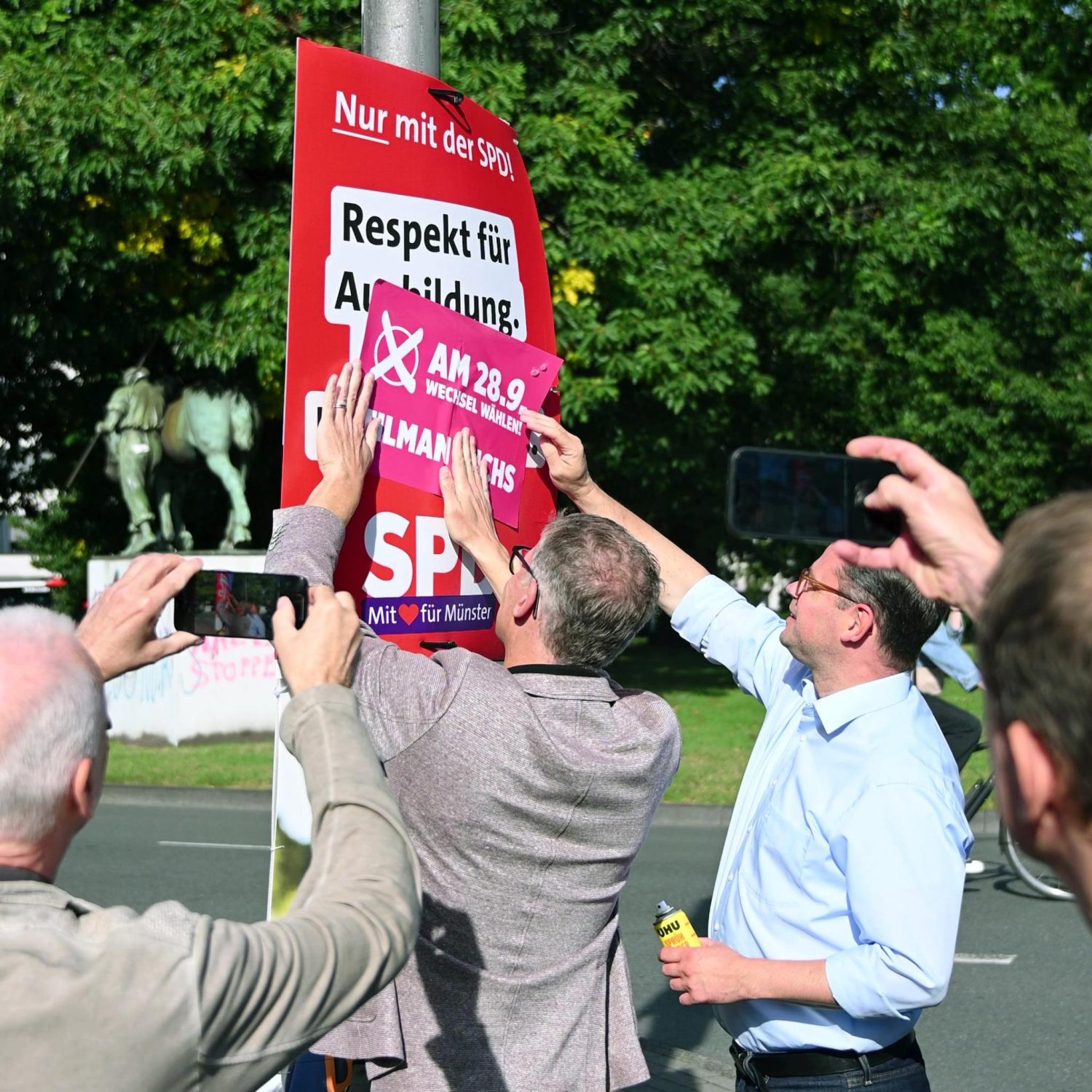 Stephan Brinktrine und Tilman Fuchs beim symbolischen Anbringen der Störer für Tilman Fuchs auf dem Wahlplakat der SPD